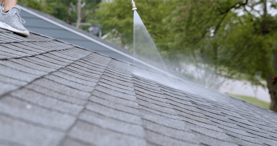 ShingleLock being sprayed across asphalt shingles on a West Michigan home